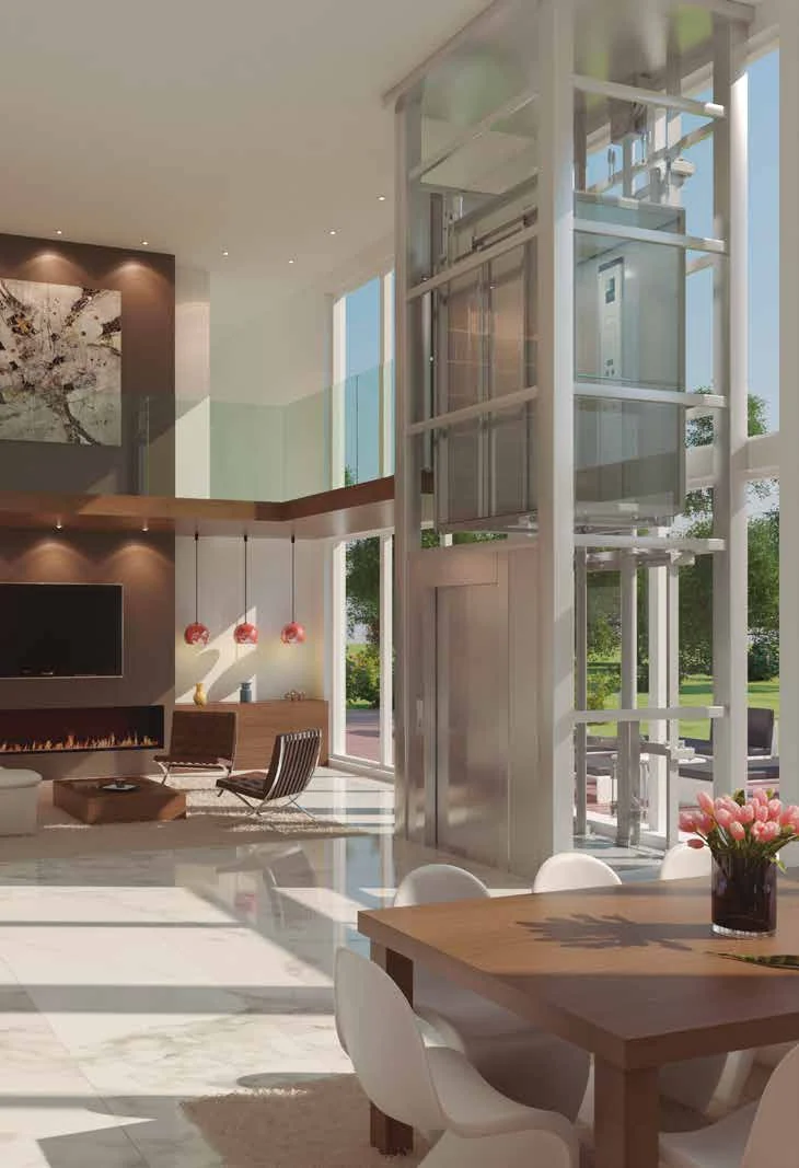 An Improlift Plus with a glazed shaft rising through a bright double-height living and dining space