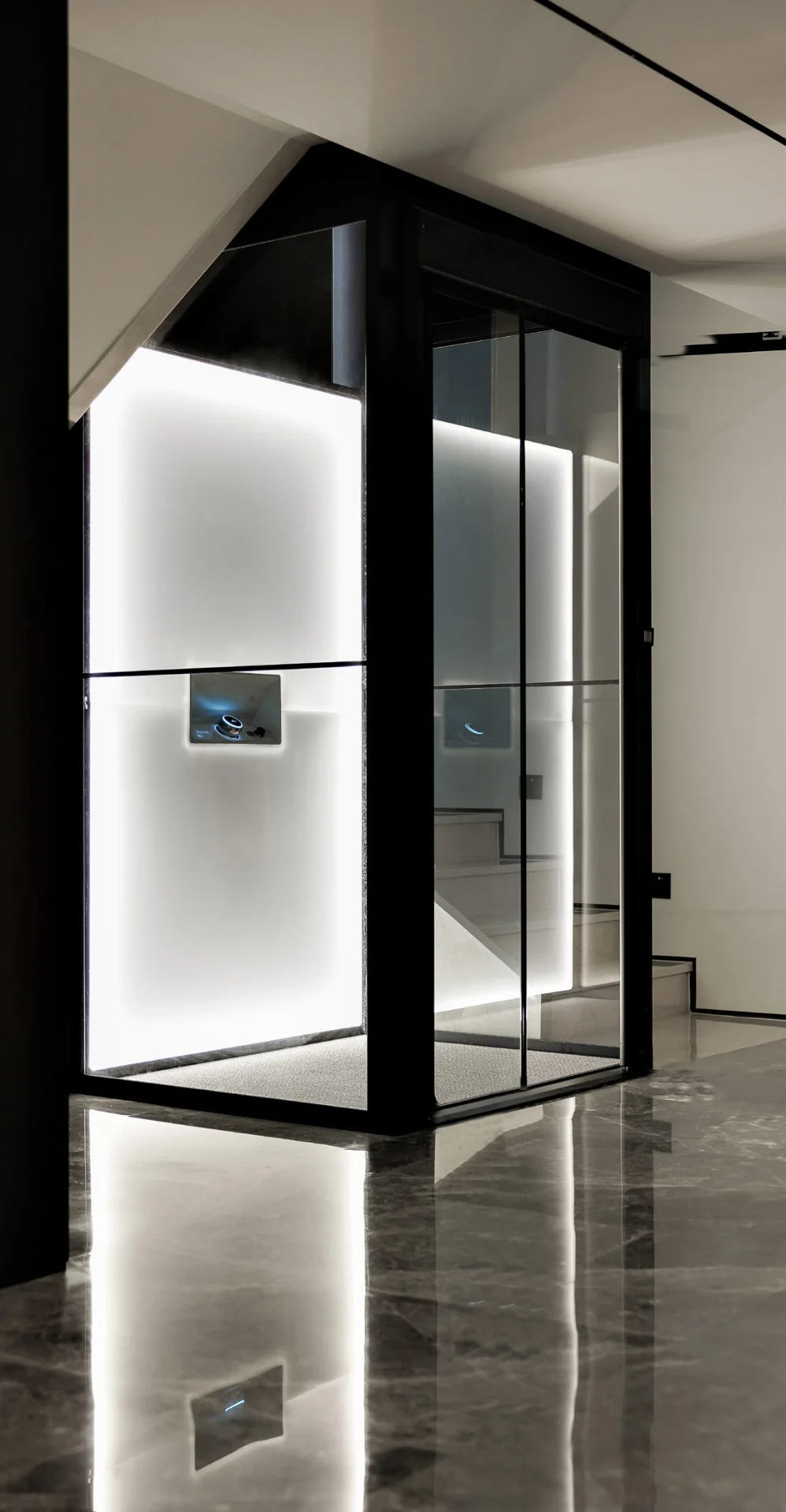 An Aritco HomeLift with a black frame and glass shaft, its backlit wall panels glowing above a polished marble floor