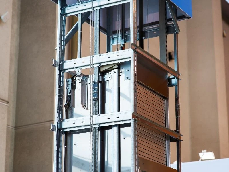 Galvanised steel lift shaft framework with guide rails and a roller shutter door