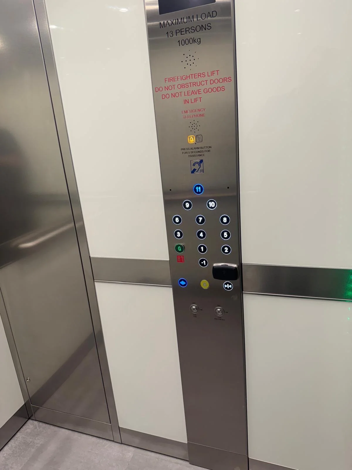 The car control panel, marked maximum load 13 persons 1000kg and firefighters lift, with buttons from -1 to 11